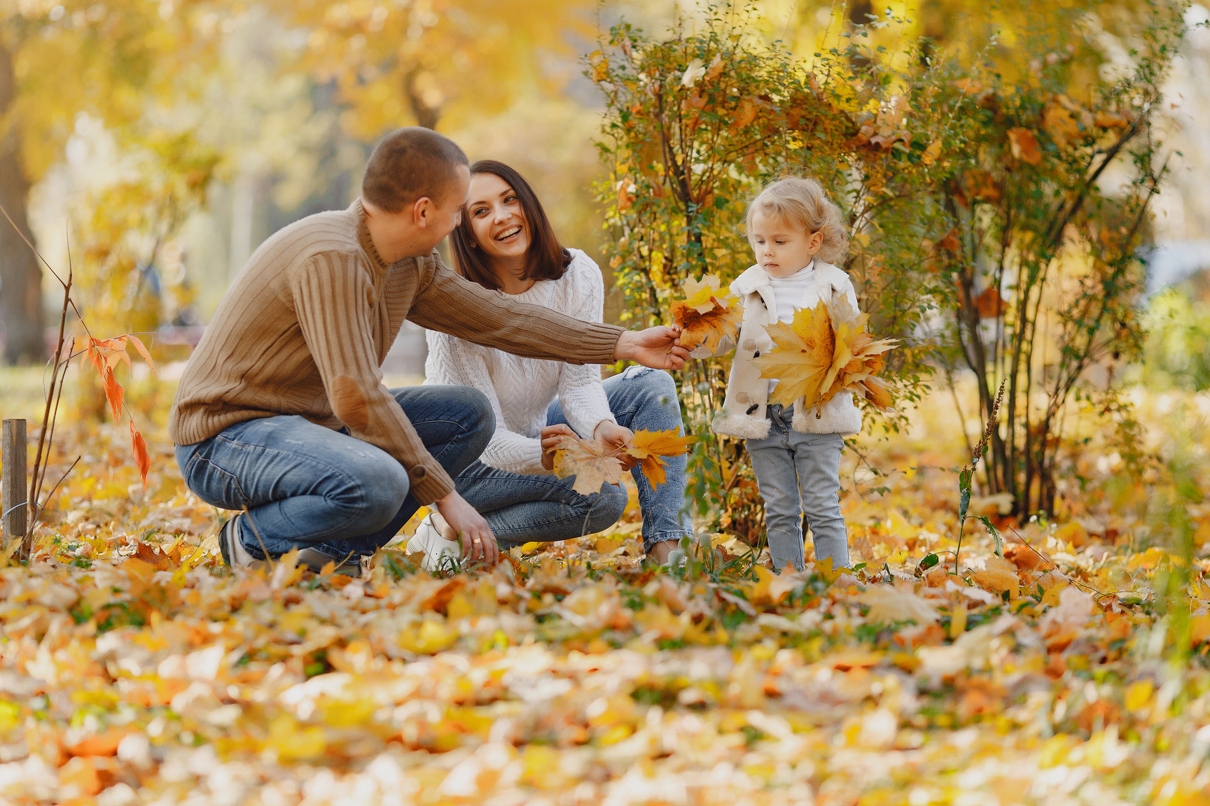 Happy family with little daughter in autumn park